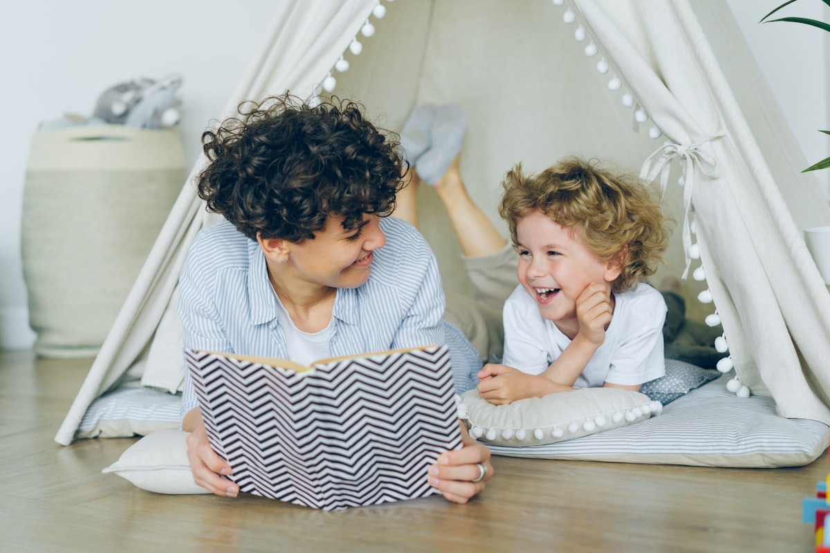 Children smiling while reading a book